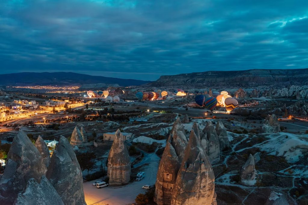 Vista nocturna de Capadocia con cielo estrellado sobre las chimeneas de hadas